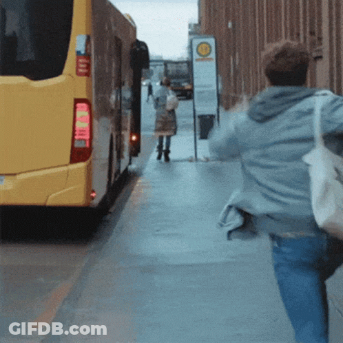 Yellow Bus Driving Past Bahnhof Sign GIF