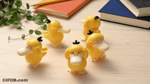 Yellow Duck Figurines On Wooden Table GIF