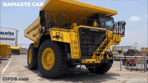 Yellow Dump Truck Parked In Front Of Building Saying Matsu GIF