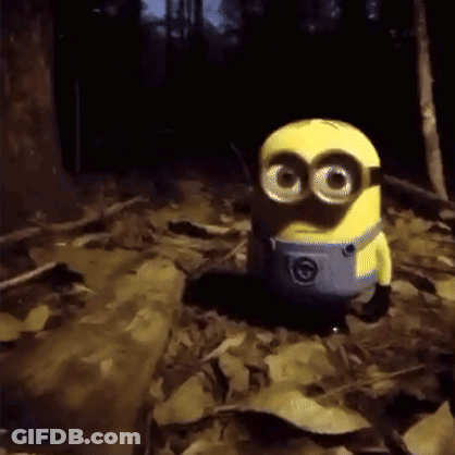 Yellow Minion Big Eyes On Leaf Pile In Woods GIF