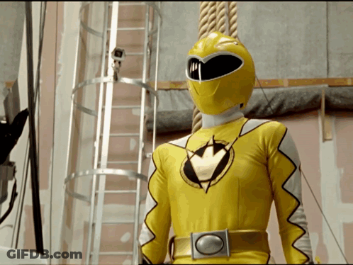 Yellow Power Ranger Standing In Front Of Camera GIF