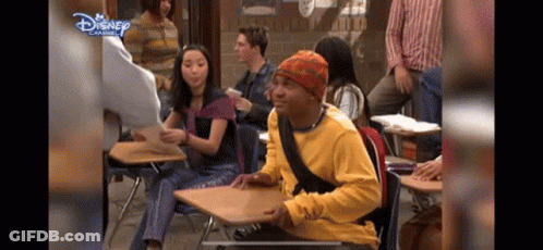 Yellow Shirt Man At Desk In Disney Classroom GIF