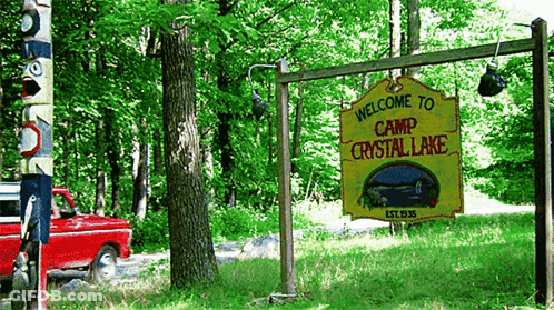 Yellow Sign Saying Welcome To Camp Crystal Lake GIF