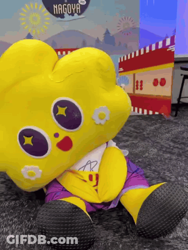 Yellow Stuffed Animal In Front Of Nagoya Sign GIF
