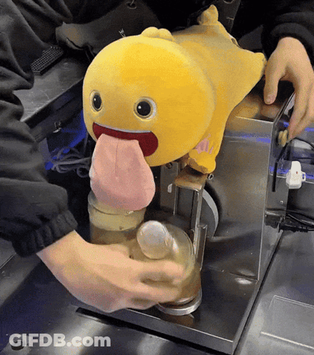 Yellow Stuffed Animal With Tongue Out Poured Into Glass GIF