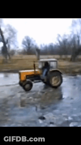 Yellow Tractor Driving Through Frozen Field GIF
