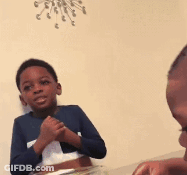 Young Boy At Table With Folded Hands GIF