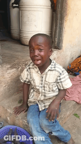 Young Boy Crying In Front Of Chemical Barrel GIF