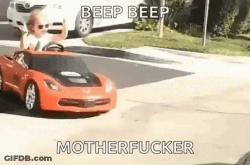 Young Boy Driving Toy Car Down Street GIF