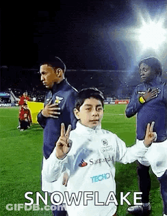 Young Boy Giving Peace Sign Next To Soccer Players GIF