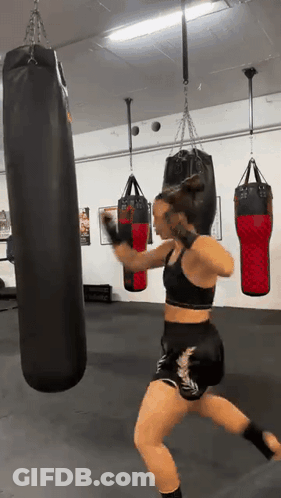 Young Boy Hitting Red Punching Bag With Boxing Gloves GIF