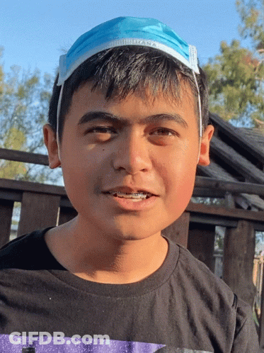 Young Boy In Black Shirt With Blue Face Mask On Head GIF