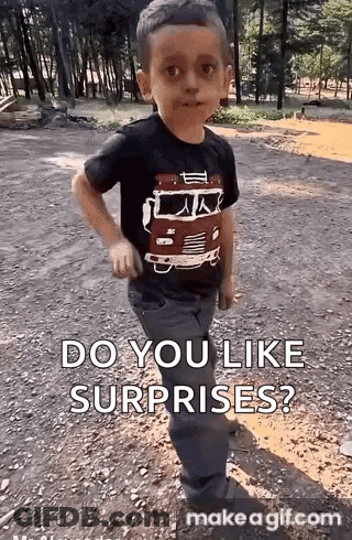 Young Boy In Black Shirt With Fire Truck Standing In Dirt GIF