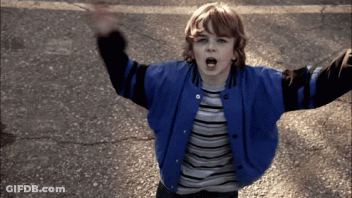 Young Boy In Blue And Black Varsity Jacket Arms Up GIF