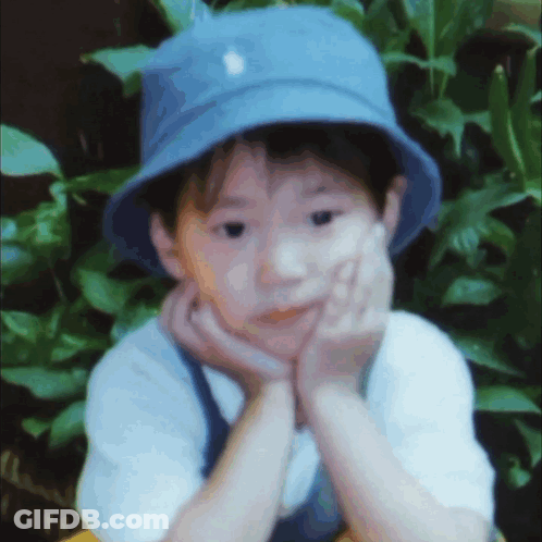Young Boy In Blue Hat Hand On Face GIF