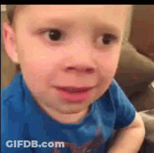 Young Boy In Blue Shirt Making Funny Face On Couch GIF