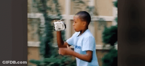 Young Boy In Blue Shirt Playing With Remote Control GIF