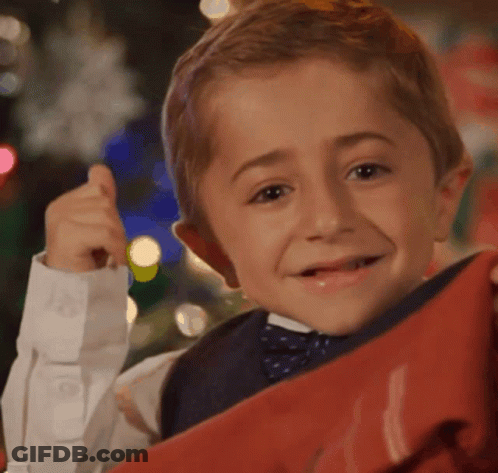 Young Boy In Bow Tie Holding Red Item GIF