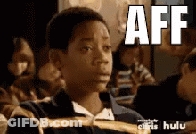 Young Boy In Classroom With Aff On Face GIF