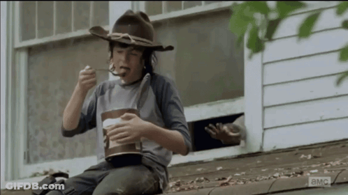 Young Boy In Cowboy Hat Eating On Roof GIF