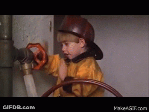 Young Boy In Fireman Hat Holding Valve GIF