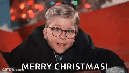 Young Boy In Glasses And Coat Laying On Red Carpet GIF