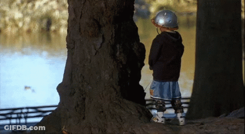 Young Boy In Helmet Next To Tree And Water GIF