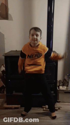 Young Boy In Nerf Sweatshirt Dancing In Front Of Fireplace GIF