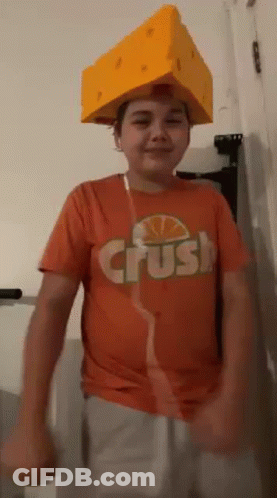 Young Boy In Orange Shirt And Cheese Hat Dancing GIF