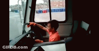 Young Boy In Orange Shirt Driving Truck GIF