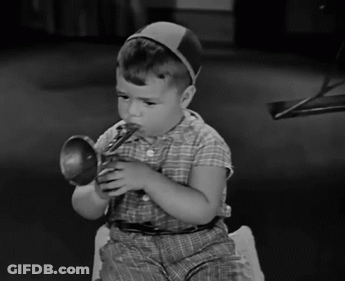 Young Boy In Plaid Shirt Playing Toy Trumpet GIF