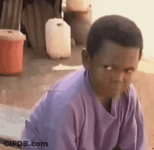 Young Boy In Purple Shirt Sitting Looking At Camera GIF