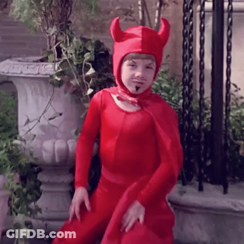 Young Boy In Red Devil Costume Standing In Front Of Planter GIF