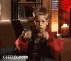Young Boy In Red Jacket Sitting With Laptop And Candle GIF