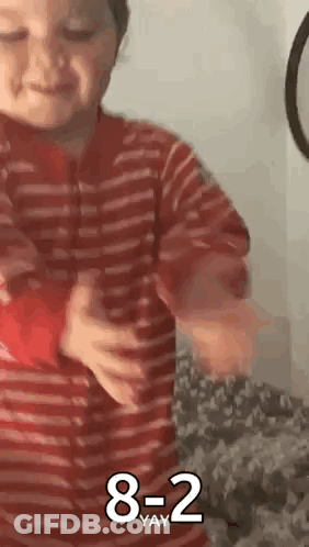 Young Boy In Red Striped Shirt Holding Red Object GIF