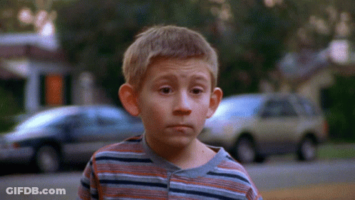 Young Boy In Striped Shirt With Cars Background GIF