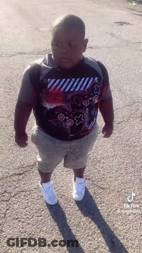 Young Boy In Video Game Controller Shirt On Street GIF
