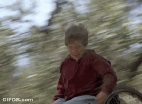 Young Boy In Wheelchair Riding Down Hill GIF