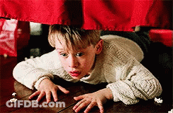 Young Boy In White Sweater Crawling Under Red Curtain GIF