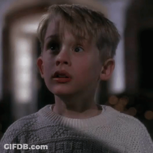 Young Boy In White Sweater Looking At Camera GIF