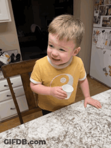 Young Boy In Yellow Shirt Holding Cup GIF