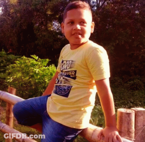 Young Boy In Yellow Superhero Shirt GIF