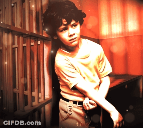Young Boy Leaning Against Wooden Fence With Th GIF