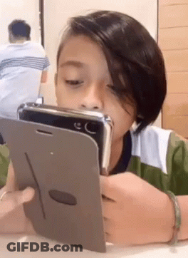 Young Boy Looking At Cell Phone GIF
