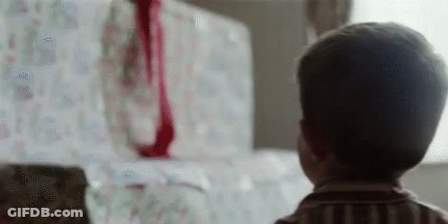 Young Boy Looking At Christmas Present GIF