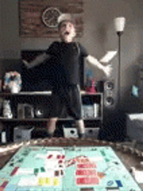 Young Boy Looking At Falling Monopoly Money GIF