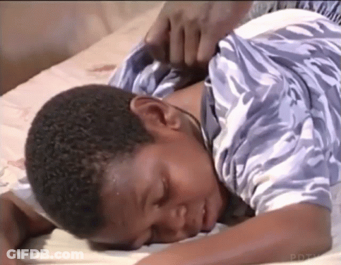 Young Boy Lying On Bed With Hand On Neck GIF