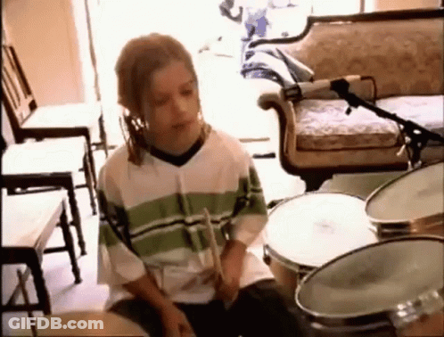 Young Boy Playing Drums In Living Room With Microphone GIF
