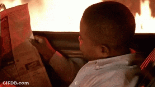 Young Boy Reading Newspaper In Car With Fire GIF