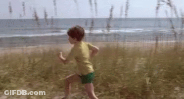 Young Boy Running On Sandy Beach GIF